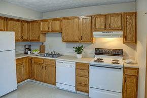 London apartment for rent - A kitchen with wooden cabinets and white appliances.
