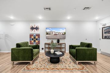 Marquette apartment for rent - A living room with a green couch, a coffee table, and a painting on the wall.