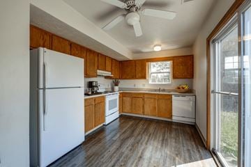 Wintersville apartment for rent - A kitchen with wooden cabinets and a white refrigerator.