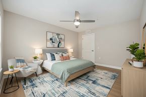 Columbus apartment for rent - A bedroom with a bed, chair, and rug.