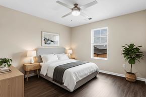 Hickory apartment for rent - A bedroom with a bed, nightstand, and a plant.