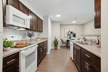 Wilton apartment for rent - A kitchen with brown cabinets and a white stove top oven.