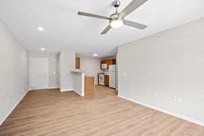 Charleston apartment for rent - an empty living room with a ceiling fan and a kitchen