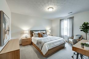 Mount Gilead apartment for rent - A bedroom with a large bed, a chair, and a painting on the wall.
