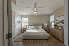 Lexington apartment for rent - A bedroom with a large bed, a ceiling fan, and a window with a view of the outside.