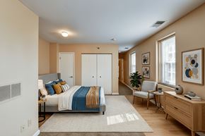 Tiffin apartment for rent - A bedroom with a bed, chair, and a painting on the wall.
