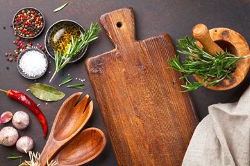 Wyoming apartment for rent - A wooden cutting board with a handle is surrounded by various herbs and spices.