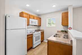 Hebron apartment for rent - a kitchen with white appliances and wooden cabinets
