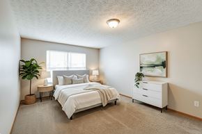 Tiffin apartment for rent - A bedroom with a large bed and a painting on the wall.