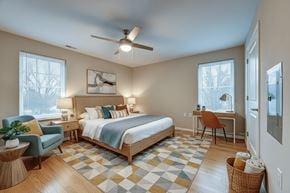 Columbus apartment for rent - A bedroom with a bed, desk, chair, and a ceiling fan.