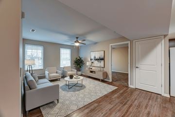 Columbus apartment for rent - A living room with a grey couch, a coffee table, and a ceiling fan.