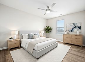 Rocky Mount apartment for rent - A bedroom with a large bed, a ceiling fan, and a nightstand with a plant on it.