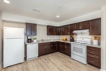 Charlotte apartment for rent - A kitchen with white appliances and brown cabinets.