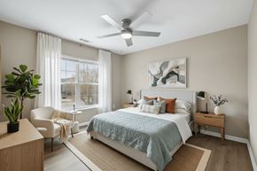 Cleveland apartment for rent - A bedroom with a bed, chair, and plant.