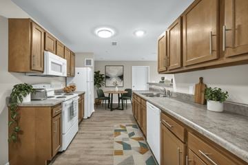 Cleveland apartment for rent - A kitchen with white appliances and wooden cabinets.