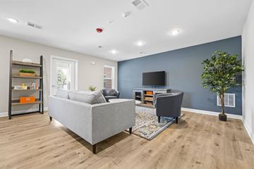Statesville apartment for rent - A living room with a grey sofa and a grey armchair.