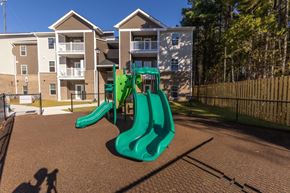 Lexington apartment for rent - A playground with a green slide in front of apartment buildings.