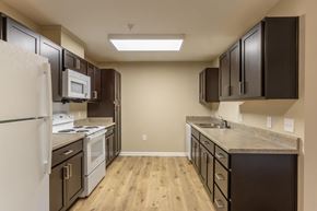 Lexington apartment for rent - A kitchen with brown cabinets and a white fridge.