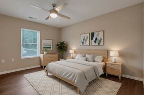 Columbus apartment for rent - A bedroom with a large bed, a ceiling fan, and two nightstands.