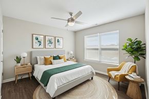 Johnston apartment for rent - A bedroom with a bed, a chair, and a ceiling fan.