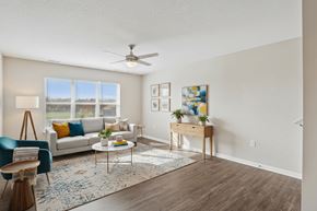 Johnston apartment for rent - A living room with a white couch, a blue chair, a wooden side table, and a rug.