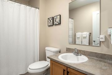 Wheeling apartment for rent - A bathroom with a toilet, sink, and shower curtain.