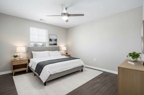 Statesville apartment for rent - A bedroom with a bed, nightstands, and a ceiling fan.