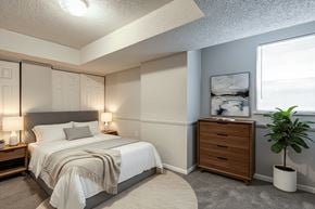 Dennison apartment for rent - A bedroom with a bed, nightstand, and a plant.