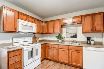 Sistersville apartment for rent - A kitchen with white appliances and wooden cabinets.