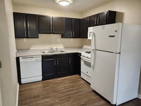 Beaufort apartment for rent - A kitchen with black cabinets and a white refrigerator.