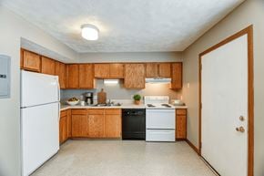 Upper Sandusky apartment for rent - A kitchen with wooden cabinets and a white refrigerator.