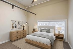 Nelsonville apartment for rent - A bedroom with a bed, nightstand, and a dresser with a plant on top.