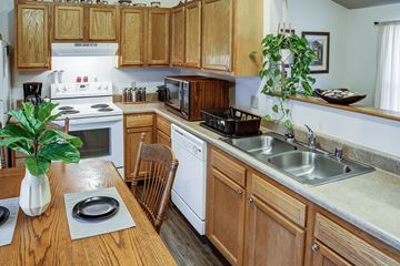 Stambaugh apartment for rent - A kitchen with wooden cabinets and a white stove top oven.