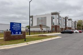 Wilson apartment for rent - A sign for Pender Crossing apartment complex stands in front of a brick building.