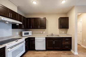 Wilson apartment for rent - A kitchen with brown cabinets and a white dishwasher.