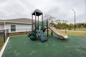 Wilson apartment for rent - A playground with a green slide and a green and red swing set.