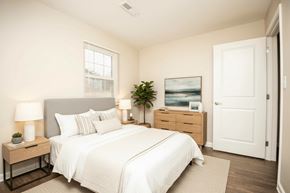 Tellico Plains apartment for rent - A bedroom with a large bed, a nightstand with a lamp, and a painting on the wall.