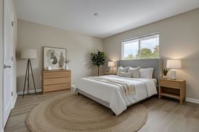Barnesville apartment for rent - A bedroom with a large bed, a nightstand, and a rug on the floor.