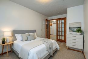 Wheeling apartment for rent - A bedroom with a bed, nightstand, and a plant.