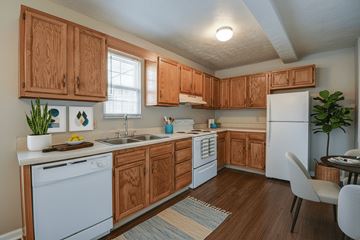 Weirton apartment for rent - A kitchen with wooden cabinets and white appliances.