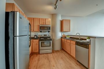 Wheeling apartment for rent - A kitchen with wooden cabinets and stainless steel appliances.