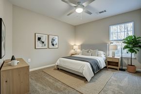 New Bern apartment for rent - A bedroom with a bed, nightstand, and a ceiling fan.