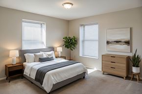 Washington Court House apartment for rent - A bedroom with a large bed, two lamps, and a painting on the wall.