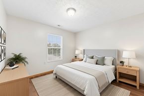 Peebles apartment for rent - A bedroom with a large bed, a nightstand, and a window with blinds.