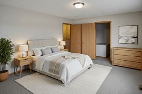 Peebles apartment for rent - A bedroom with a large bed, a nightstand with a lamp, and a plant.