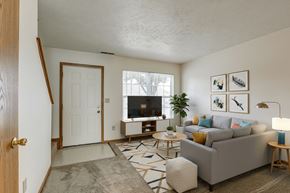 Ottawa apartment for rent - A living room with a grey couch, a coffee table, a rug, and a TV.