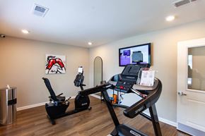 New Bern apartment for rent - a home gym with a treadmill and a tv on the wall