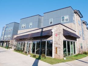 Atlanta apartment for rent - the front of a building with glass windows and a sidewalk