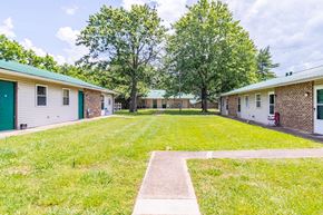 Dickson apartment for rent - a yard in front of two buildings with trees in the background