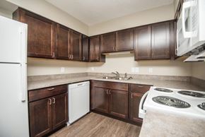 Tellico Plains apartment for rent - a kitchen with dark wood cabinets and white appliances
